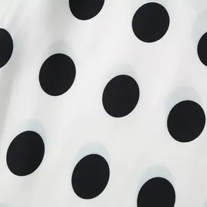 Close-up of elegant black and white polka dot fabric texture for women's apparel set