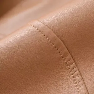 Vue rapprochée d'une matière en simili cuir marron avec des détails de couture fins