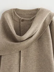 Detailansicht eines braunen Strickmantels mit asymmetrischem Schalkragen und Knopf