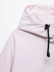 Dettaglio di una giacca impermeabile rosa chiaro con cappuccio a coulisse nero regolabile