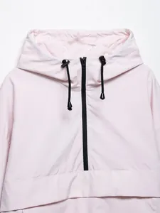 Primo piano di una giacca a vento rosa chiaro con cappuccio e cerniera lampo.