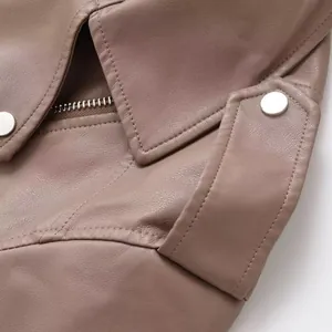 Gros plan détaillé d'un blouson motard en similicuir marron avec bouton pression argenté