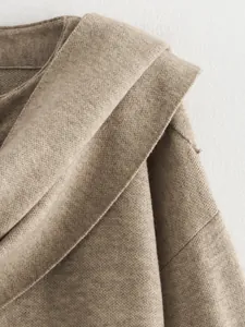 Detailansicht eines braunen Strickmantels mit asymmetrischem Schalkragendetail