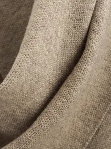 Nahaufnahme der weichen kamelbraunen Strickstofftextur mit feiner Webstruktur