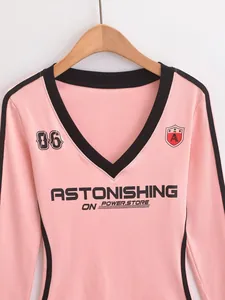 Gedetailleerd overzicht van roze T-shirt met lange mouwen en zwarte ASTONISHING-opdruk