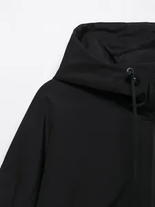 Dettaglio ravvicinato di una giacca a vento nera con cappuccio e coulisse regolabile