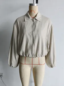 Dettaglio di una giacca alla moda beige da donna con cerniera lampo e orlo a sbuffo