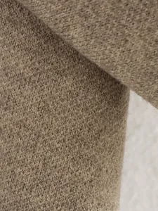 Nahaufnahme des kamelbraunen Strickstoffs mit feiner Textur und weichem Wollfinish.
