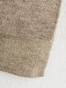 Detaillierte Nahaufnahme der hochwertigen weichen braunen Strickstruktur des Damenmantels