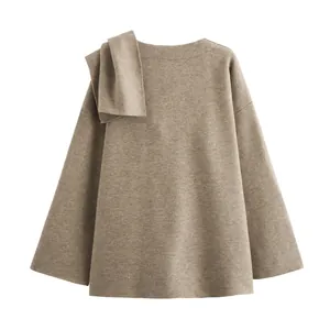Detailansicht eines braunen Strickmantels mit einem asymmetrischen Schalakzent.