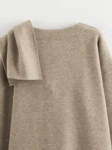 Detailansicht eines minimalistischen khakifarbenen Strickmantels mit asymmetrischem Schal.