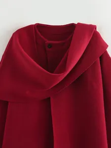 Detailansicht eines roten Kurzstrickmantels mit asymmetrischem Schalkragen.