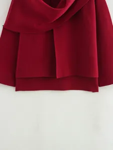 Detailansicht eines burgunderroten Strickmantels mit asymmetrischem Schalkragen.