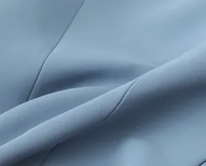 Close-up detail of light blue high-quality pleated fabric texture for women's suit
