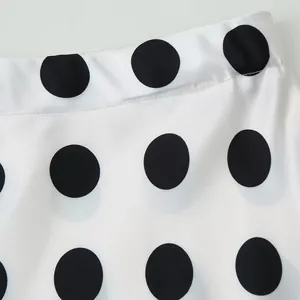 Close-up macro detail of premium white fabric with black polka dots and fine stitching