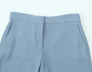 Close-up of high-waisted dusty blue trousers showing waist and pocket detail