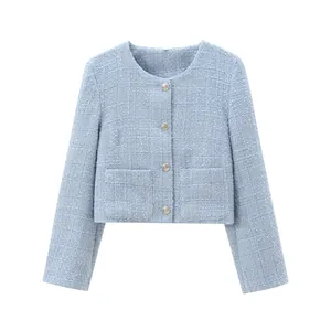 Detailed view of light blue tweed jacket featuring a round neck and gold buttons