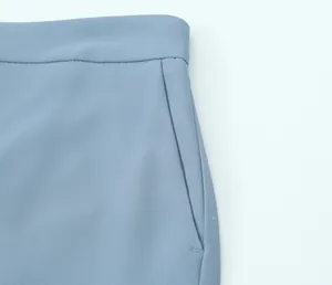 Detail view of high-waisted blue casual trousers showing side pocket and stitching quality