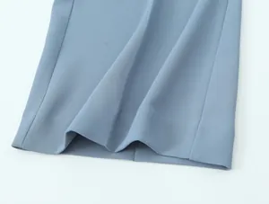 Macro view of light blue high waist trousers fabric texture showing fine weave and hem detail