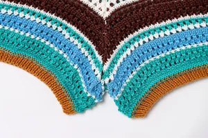 Makroansicht der detaillierten Textur des mehrfarbig gestreiften Häkelstrickstoffs