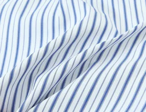 Dettaglio macro che mostra la morbida trama del tessuto estivo a righe blu e bianche