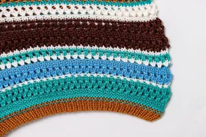 Nahaufnahme von bunt gestreiftem Häkelstrick, das die Textur und Handwerkskunst zeigt.