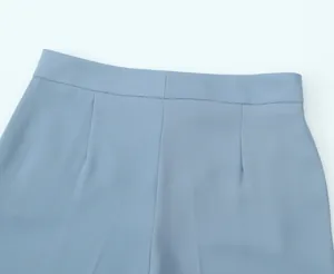 Detailed macro view showing the high-waisted seam and darts on blue elegant trousers
