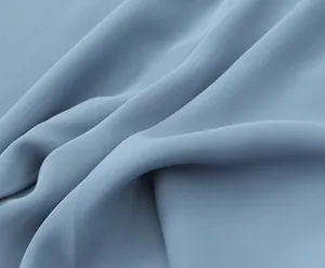 Macro view showing the fine twill weave and soft drape of the light blue fabric