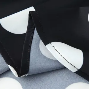 Macro view of black and white polka dot fabric with clean hem stitching details