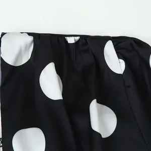 Close-up of black and white polka dot fabric showing texture and elegant drape details.