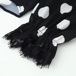 Detailed macro view of black polka dot top sleeve with elastic cuff and lace trim.
