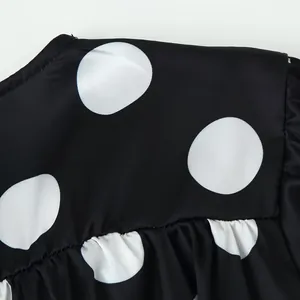 Close-up showing the high-quality black and white polka dot fabric texture and delicate ruffles