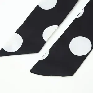 Detail view of the black and white polka dot fabric texture for elegant women's set