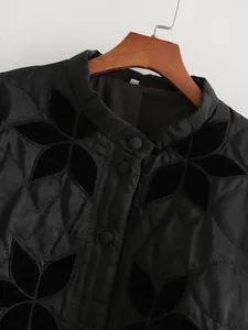 Dettaglio di una giacca nera in stile francese con design patchwork di fiori in velluto