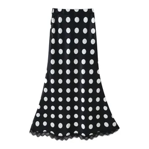 Detailed view of elegant black and white polka dot high-waist skirt with lace trim