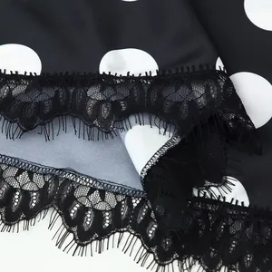 Exquisite detail view of black eyelash lace trim on elegant polka dot fabric dress