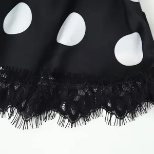 Detail view of premium black polka dot fabric with elegant eyelash lace trim hemline