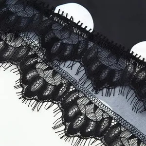 Close-up detail of elegant black eyelash lace trim on polka dot fabric women garment