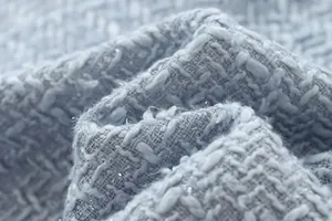 Close-up of light blue tweed fabric with silver thread detail for elegant jackets