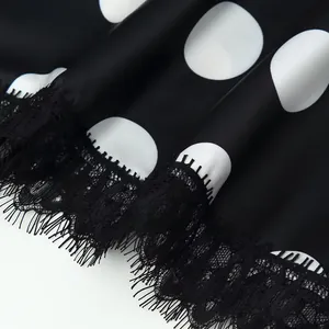 Close-up of elegant black polka dot satin fabric with delicate eyelash lace trim detail