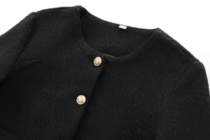 Close-up of black tweed jacket featuring elegant round neck and gold-tone buttons detail