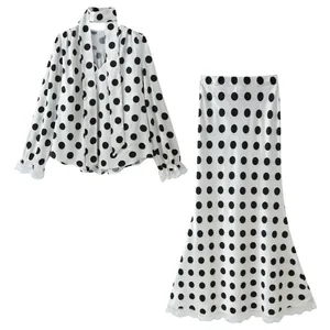 Elegant white and black polka dot two-piece set featuring V-neck blouse and midi skirt