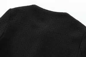 Close-up macro shot of the black tweed fabric texture on a stylish round neck jacket