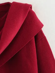 Nahaufnahme eines burgunderfarbenen Strickmantels mit weicher Textur und asymmetrischem Kragen.