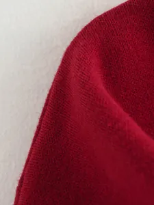 Makroansicht der weichen roten Strickstofftextur für modischen Damenkurzmantel
