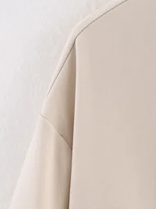Macro-opname van hoogwaardige twillstof en duurzame stiksels op een modern beige modejack detail.