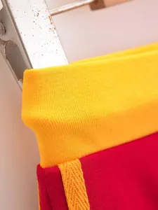 Detailopname van de rood-gele kleurblok geribbelde tailleband op retro short