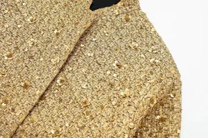 Nahaufnahme einer goldfarbenen Pailletten-Tweedjacke mit hochwertigen Texturdetails.