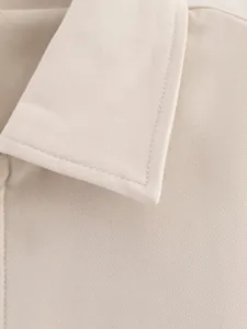 Macro-opname van hoogwaardige twill stof en professionele stiksels op een beige jas kraag