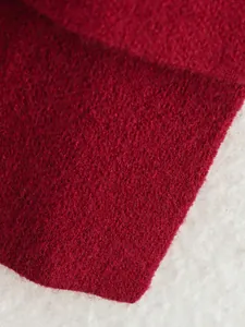 Hochwertige Nahaufnahme der weichen roten Strickstofftextur für einen modischen Mantel